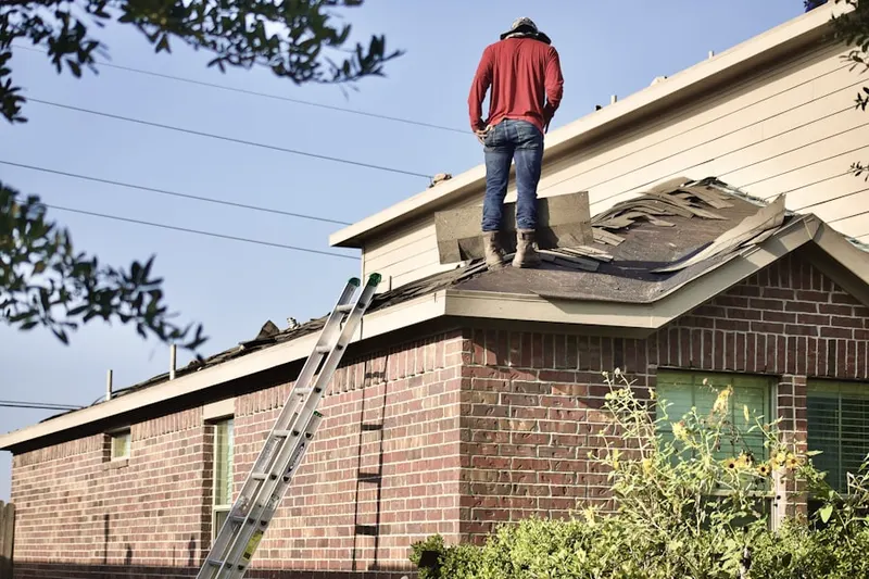 Professional roofer working on a residential roof in Monroe Gardens
